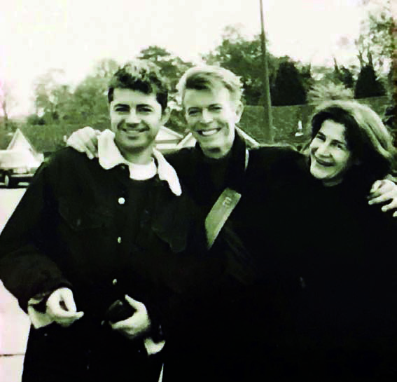 Black and white photo of David Bowie with two other individuals.