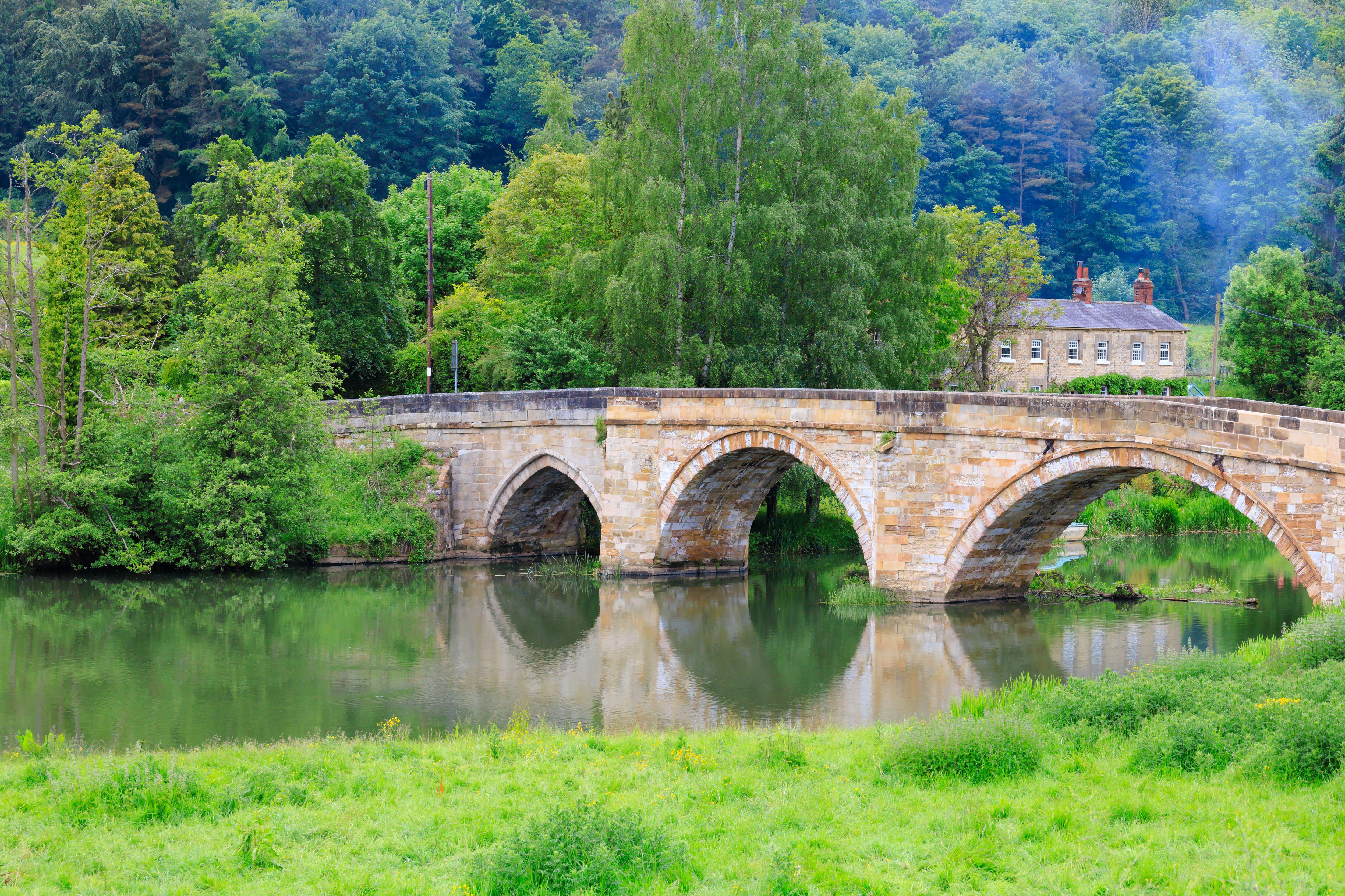 Medieval stone arch bridge over a river.